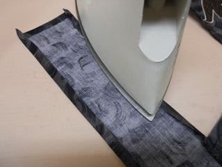 Pressing remaining folded tie edges