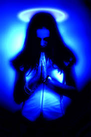 Praying girl with halo in glowing light