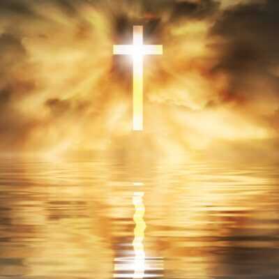 Shining cross in golden water horizon